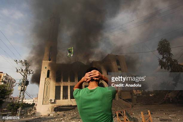 Palestinian man reacts after an Israeli air strike hits El-Emin Mohammed mosque in Gaza City, Gaza on July 29, 2014. Israeli army said Tuesday that...