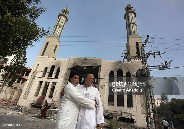 Palestinian men react after an Israeli air strike hits El-Emin Mohammed mosque in Gaza City, Gaza on July 29, 2014. Israeli army said Tuesday that...