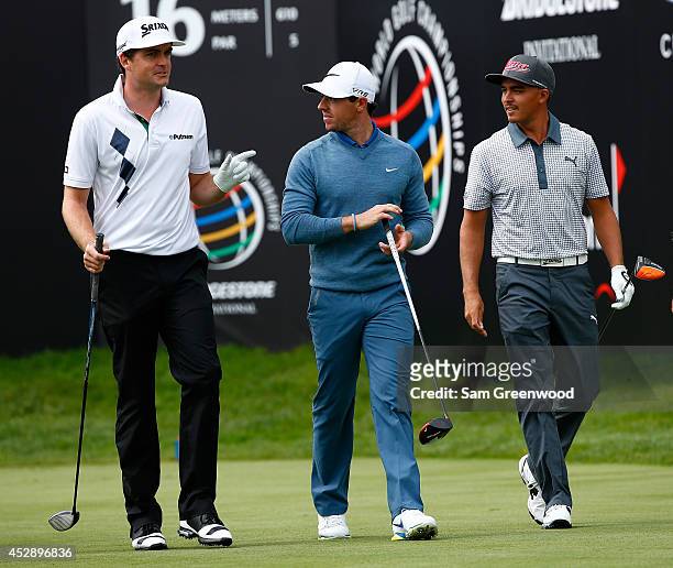Keegan Bradley , Rory McIlroy of Ireland and Rickie Fowler walk down the 16th hole during a practice round for the World Golf...