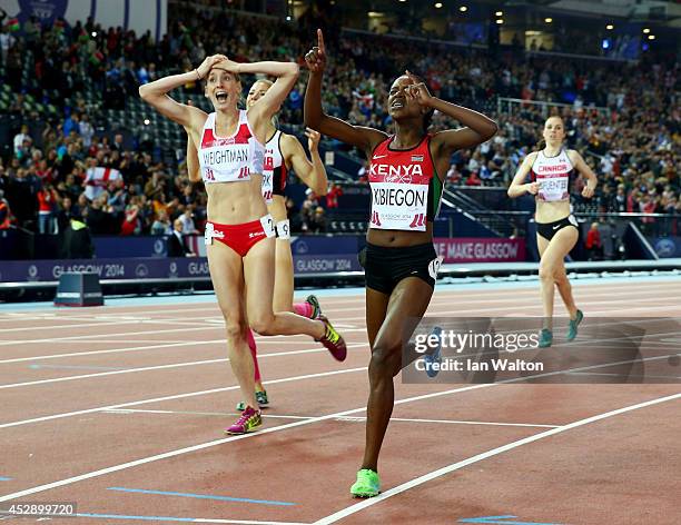 Silver medalist Laura Weightman of England and gold medalist Faith Kibiegon of Kenya react as they cross the finish line in the Women's 1500 metres...