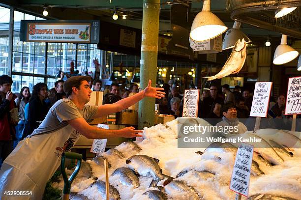 Washington State, Seattle, Pike Place Market, Fresh Seafood Stand, Flying Fish Show, Vendor Throwing Salmon.