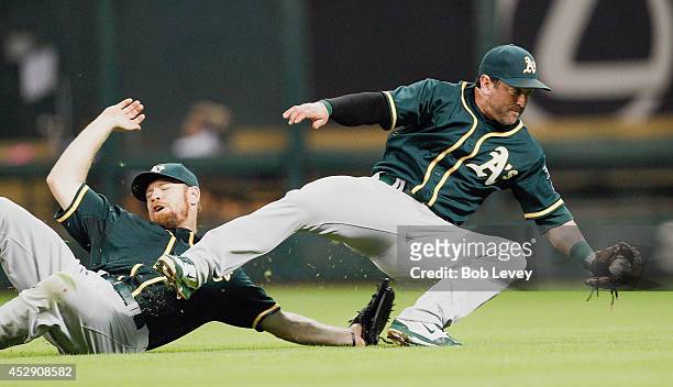 Nick Punto of the Oakland Athletics avoids a collision with Brandon Moss as he makes the final out against the Houston Astros at Minute Maid Park on...