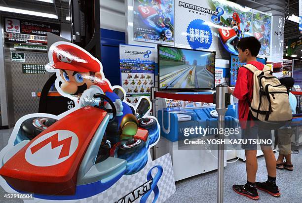 Customers play with Nintendo's videogame console Wii U at an electronics shop in Tokyo on July 30, 2014. Japanese videogame giant Nintendo posted a...