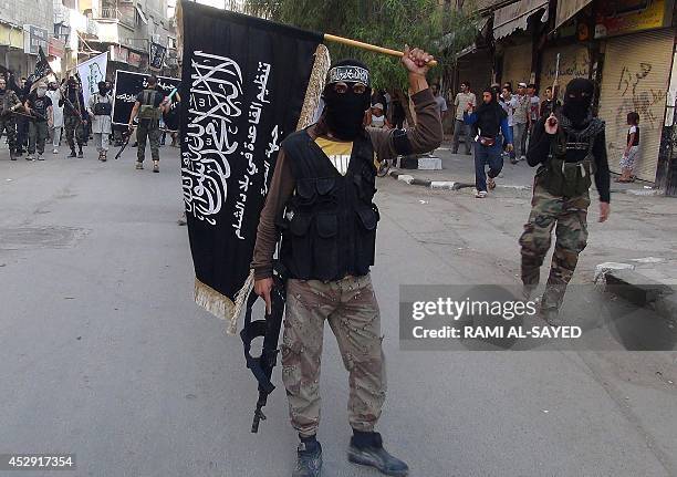 Islamic fighters from the al-Qaida group in the Levant, Al-Nusra Front, wave their movement's flag as they parade at the Yarmuk Palestinian refugee...