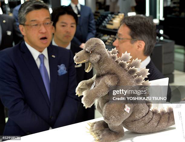 Hiroshi Onishi , the president of Japan's Isetan department store, looks at a Godzilla cuddly toy, made by German teddy bear maker Steiff, at the...