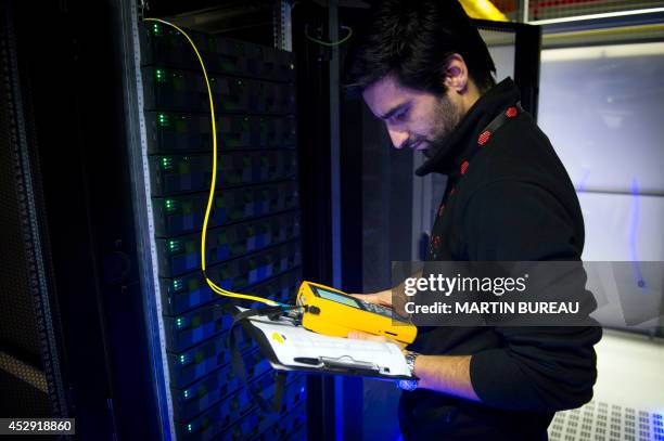 An employee of Equinix data center checks servers on July 21, 2014 in Pantin, a suburb north of Paris in the Seine-Saint-Denis department. Data...