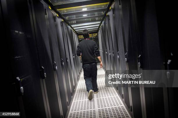An employee of Equinix data center walks as he checks servers on July 21, 2014 in Pantin, a suburb north of Paris in the Seine-Saint-Denis...