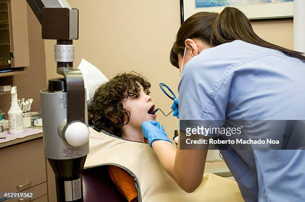Hispanic boy in the dentist chair getting prepared for an X-Ray, dentistry office for children.