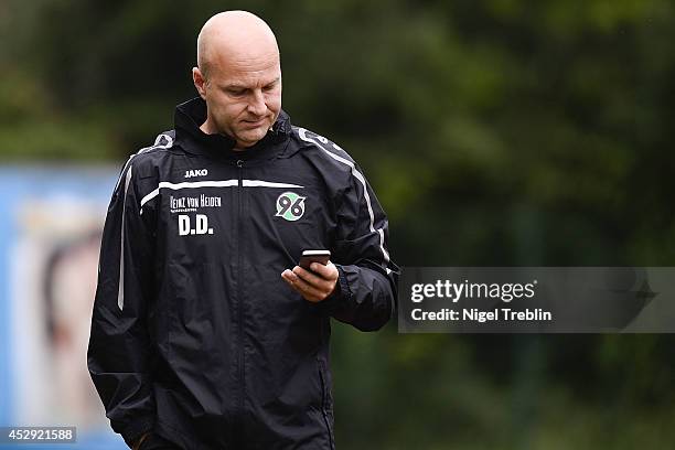 Manager Dirk Dufner of Hannover looks on his mobile phone at Hannover 96 training camp on July 30, 2014 in Mureck, Austria.