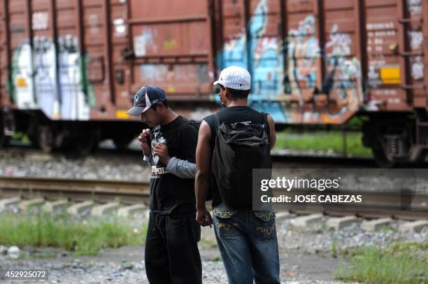 Immigrants stand beside the railtracks in Tierra Blanca, Veracruz, Mexico, on August 21, 2010 waiting for a chance to board a train heading north....