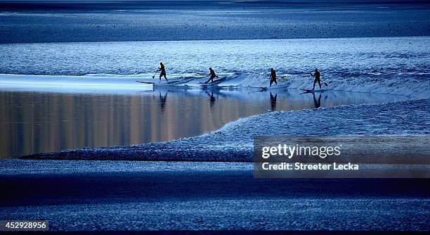 Group of surfers ride the Bore Tide at Turnagain Arm on July 14, 2014 in Anchorage, Alaska. Alaska's most famous Bore Tide, occurs in a spot on the...