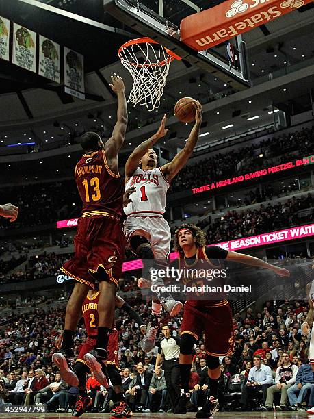 Derrick Rose of the Chicago Bulls drives to the basket between Tristan Thompson and Anderson Varejao of the Cleveland Cavaliers at the United Center...