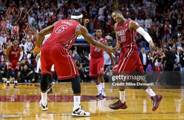 LeBron James and Mario Chalmers of the Miami Heat high five during a game against the Charlotte Bobcats at American Airlines Arena on December 1,...