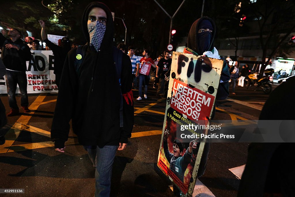 A masked protester waves a black flag during a protest...