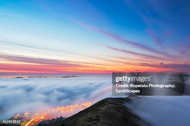 fire on fog - golden gate bridge city fog stock-fotos und bilder