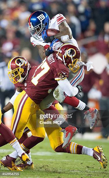 New York Giants running back Michael Cox is picked up and dumped by Washington Redskins strong safety Reed Doughty on a kickoff return during the...