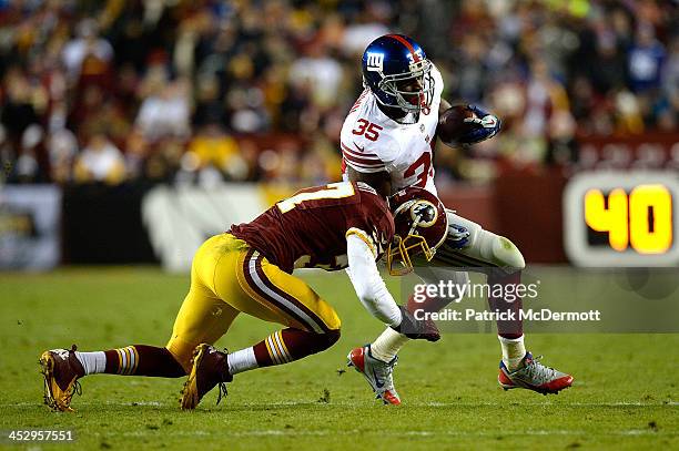 Andre Brown of the New York Giants is tackled by Reed Doughty of the Washington Redskins in the first half during an NFL game at FedExField on...