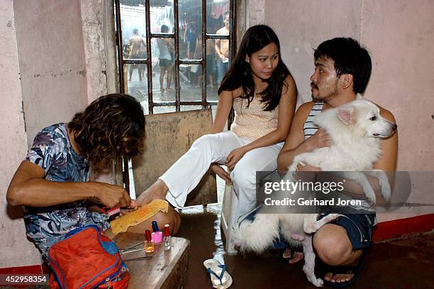 Mary Jane Palima gets a manicure from an inmate while talking to her boyfriend Anthony Chiu in their VIP cell at the Sputnik gang barrack at the...