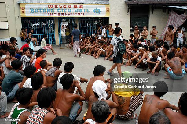 Marites Biado walks past gang members from BCJ during one of the 4 daily countings. The BCJ is one of 4 major gangs in Manila City Jail. Marites...