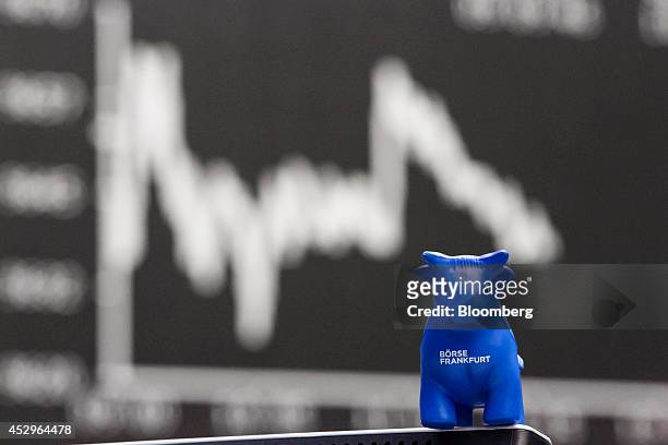Bull toy figurine is seen as the DAX Index curve is displayed on an electronic board at the Frankfurt Stock Exchange in Frankfurt, Germany, on...