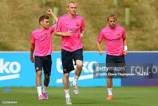 Jrmy Mathieu of Barcelona, centre, warms up during a training session at St George's Park on July 31, 2014 in Burton-upon-Trent, England.