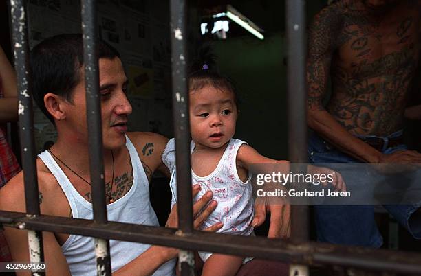 Baby girl with her father, who is a member of Batang City Jail Gang, one of four gangs at Manila City Jail. The girl lives with her mother and father...