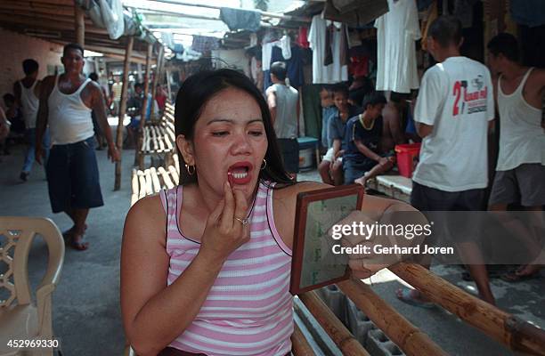 Christina Bunuan puts on make up. She stays with her husband Joey at their barrack in the Manila City Jail. Sputnik is one of 4 major gangs in Manila...