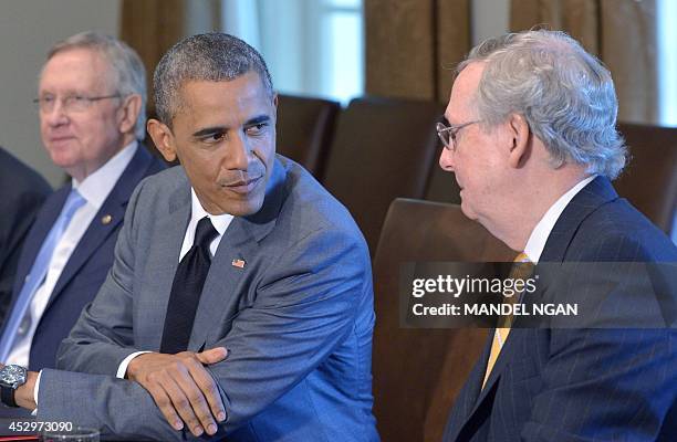 President Barack Obama looks at Senate Minority Leader Mitch McConnell , R-KY, while meeting with members of Congress on foreign policy on July 31,...