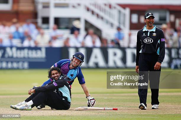 Tillakaratne Dilshan of Surrey and Eoin Morgan of Middlesex pick themselves up after colliding as Vikram Solanki of Surrey laughs during the Royal...