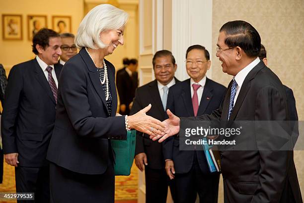 In this handout photo provided by IMF, International Monetary Fund Managing Director Christine Lagarde shakes hands with Prime Minister Hun Sen at...