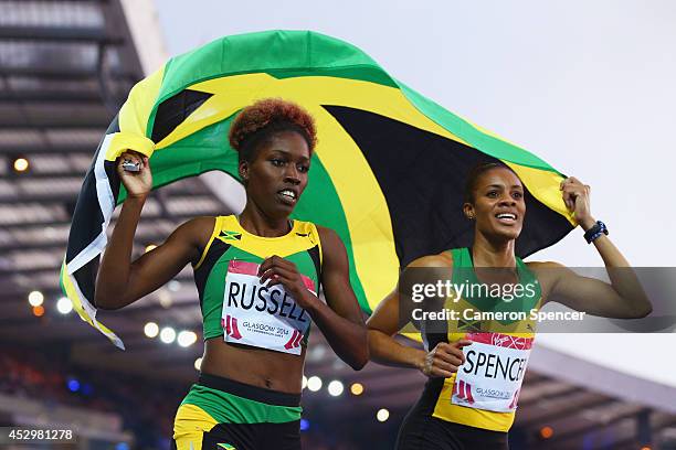 Bronze medalist Janieve Russell of Jamaica and Gold medalist Kaliese Spencer of Jamaica celebrate the Women's 400 metres hurdles final at Hampden...