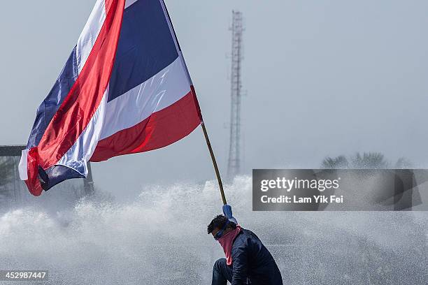 Riot police use tear gas and water cannon as anti-government protesters try to occupy the government house on December 2, 2013 in Bangkok, Thailand....