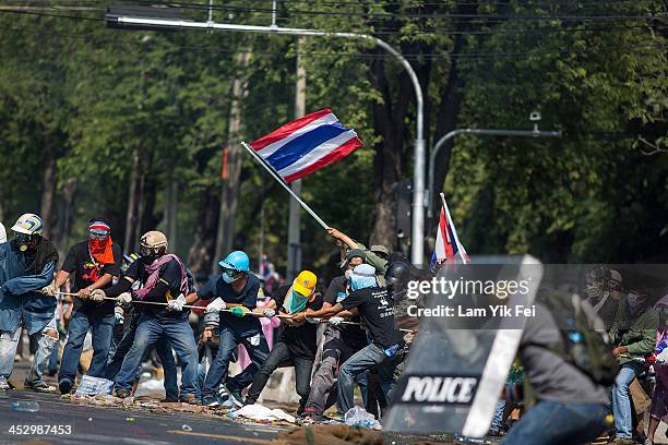 Anti-government protesters remove part of a barricade as they attempt to occupy the government house on December 2, 2013 in Bangkok, Thailand....