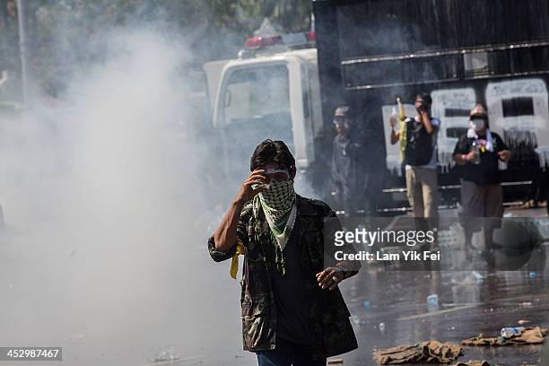 Riot police use tear gas and water cannon as anti-government protesters try to occupy the government house on December 2, 2013 in Bangkok, Thailand....