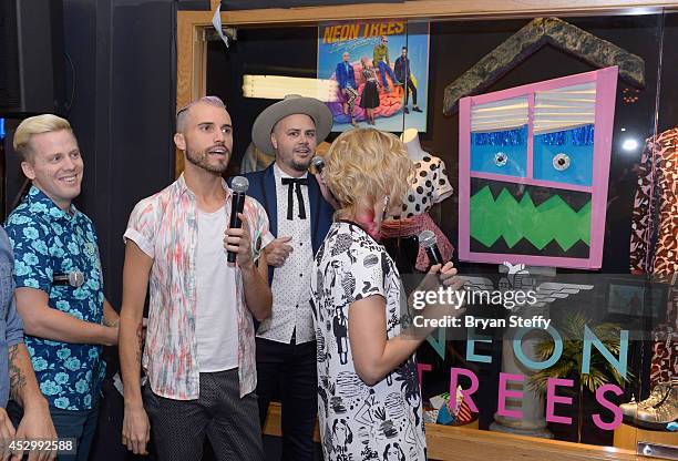 Guitarist Chris Allen, singer/keyboardist Tyler Glenn, bassist Branden Campbell and drummer Elaine Bradley of Neon Trees appear at a memorabilia case...