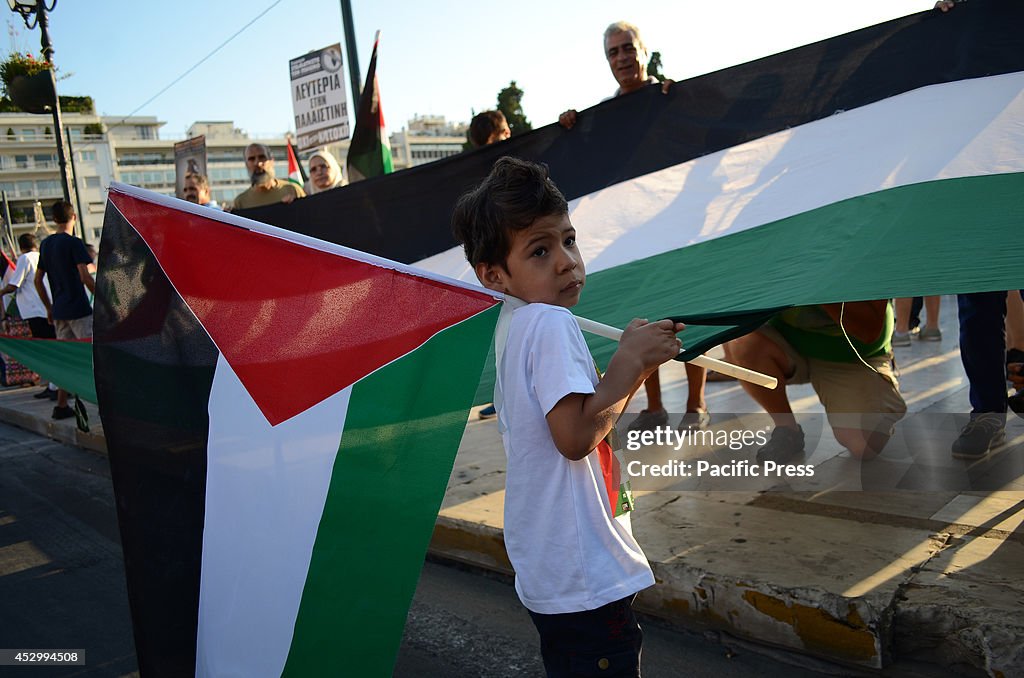 A young boy holds a big flag of Palestine during the protest...