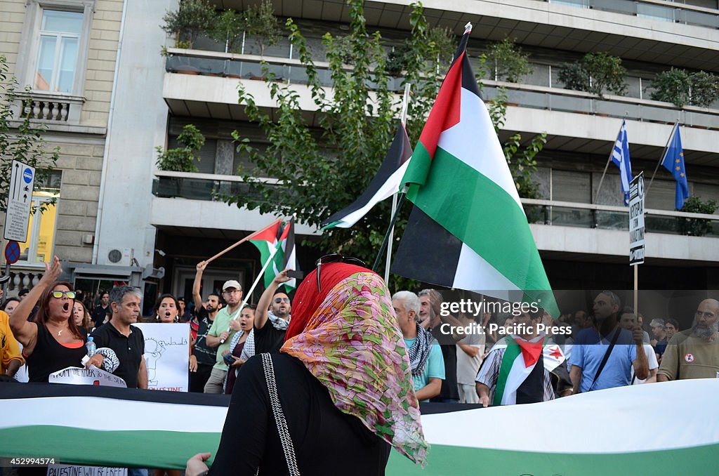 Demonstrators shout slogans and wave flags of Palestine...
