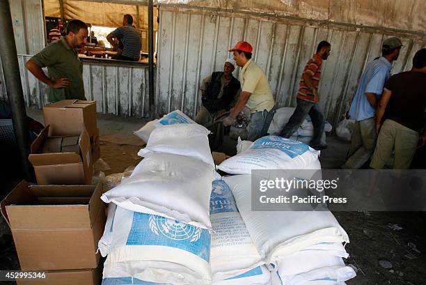 Palestinians receive their monthly food aid at a United Nations distribution center in the Rafah refugee camp, Southern Gaza Strip. Palestinian...