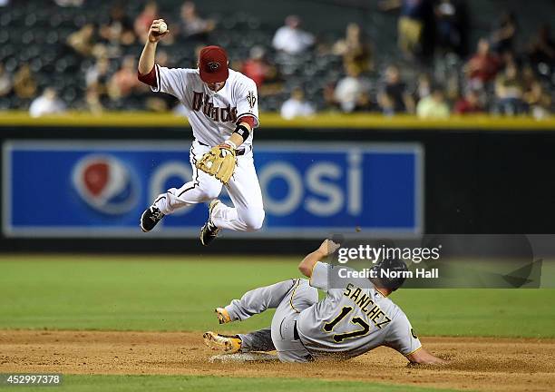 Aaron Hill of the Arizona Diamondbacks attempts to turn a double play while leaping over Gaby Sanchez of the Pittsburgh Pirates at Chase Field on...