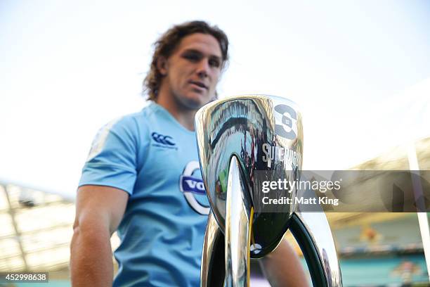 Waratahs captain Michael Hooper looks at the Super Rugby trophy during the Super Rugby media opportunity at ANZ Stadium on August 1, 2014 ahead of...