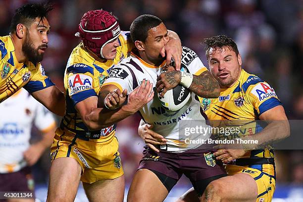 Josh Hoffman of the Broncos is tackled by Matt Ballin and Anthony Watmough of the Sea Eagles during the round 21 NRL match between the...