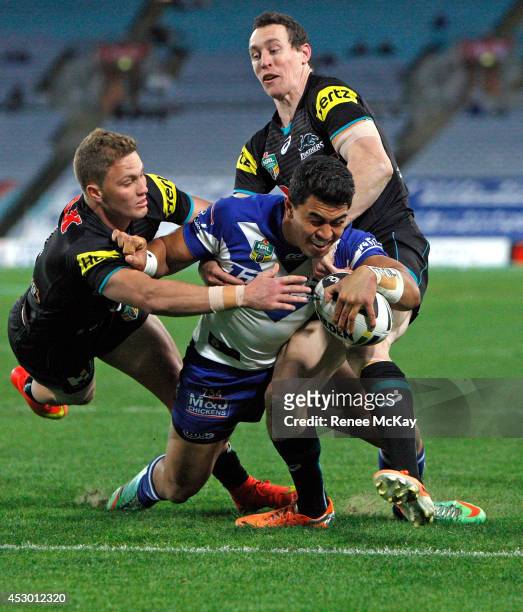 Tim Lafai of the Bulldogs loses the ball as he is tackled by Matt Moylan during the round 21 NRL match between the Canterbury Bulldogs and the...