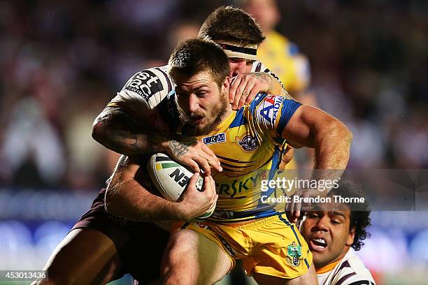 Kieran Foran of the Sea Eagles is tackled by Josh McGuire and Sam Thaiday of the Broncos during the round 21 NRL match between the Manly-Warringah...