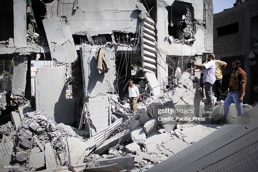 A Palestinian man reacts upon seeing his destroyed house in...