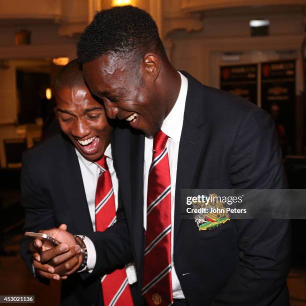 Ashley Young and Danny Welbeck of Manchester United laugh as they look at their phone as they arrive in Detroit as part of their pre-season tour of...