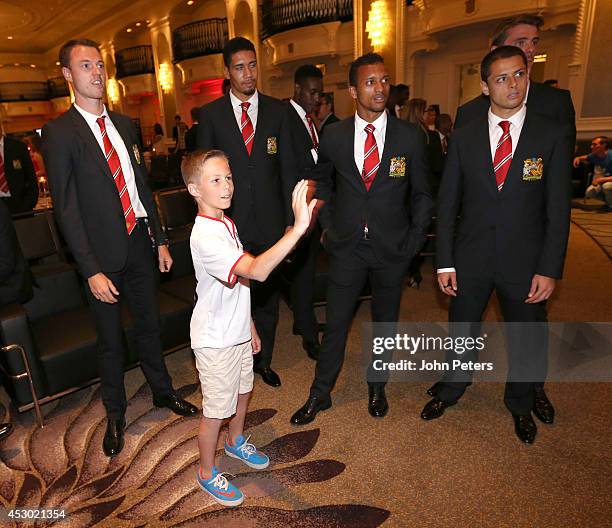 Nani, Jonny Evans, Chris Smalling, David de Gea and Javier "Chicharito" Hernandez of Manchester United pose with a young fan as they arrive in...