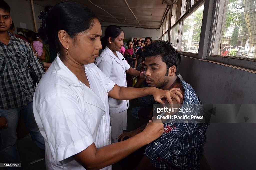 An Indian boy receives vaccine against Japanese encephalitis...