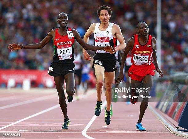 Moses Kipsiro of Uganda crosses the line to win gold ahead of Silver medalist Josphat Kipkoech Bett of Kenya and Bronze medalist Cameron Levins in...