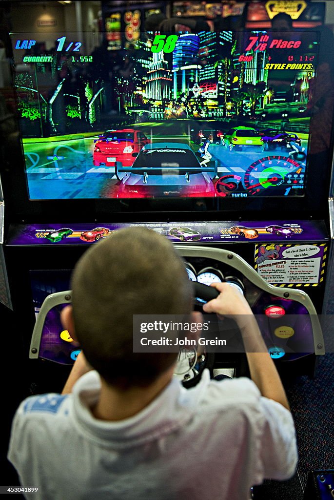 Boy playing video games at an arcade...