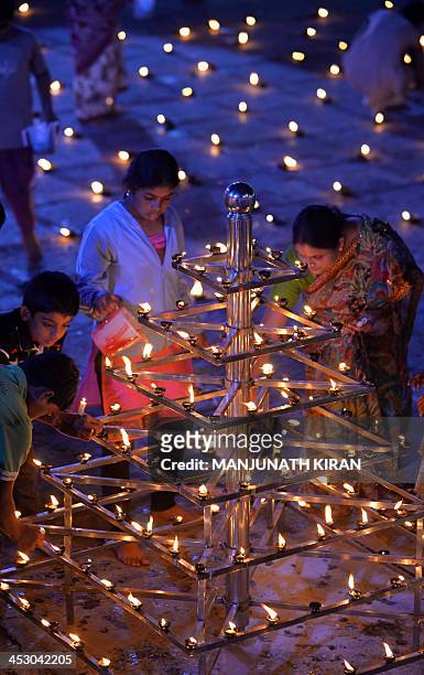 Hindu devotees light oil lamps at a temple for the Hindu God Shiva during the "Karthigai Deepam" in Bangalore on December 2, 2013. "Karthigai Deepam"...
